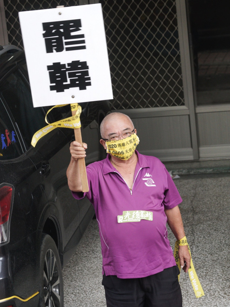 一位市民高舉「罷韓」手舉牌，向罷韓車隊揮手致意。   圖：張良一/攝