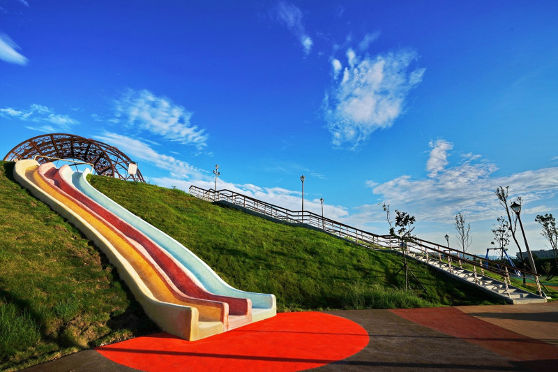 公園有長20公尺的磨石子滑梯，以及好幾種共融式遊樂設施。   圖：新北市政府高灘地工程管理處／提供
