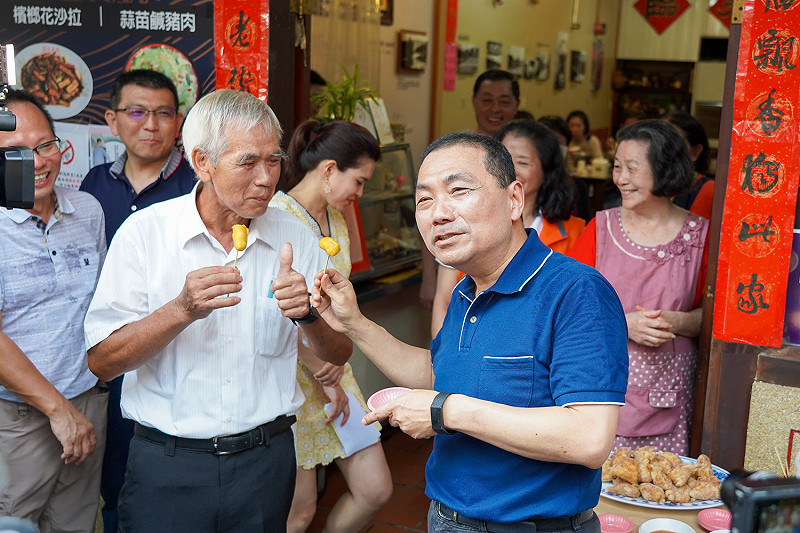 新北市長侯友宜與商圈業者互動，推廣商圈美食。   圖：新北市經發局提供