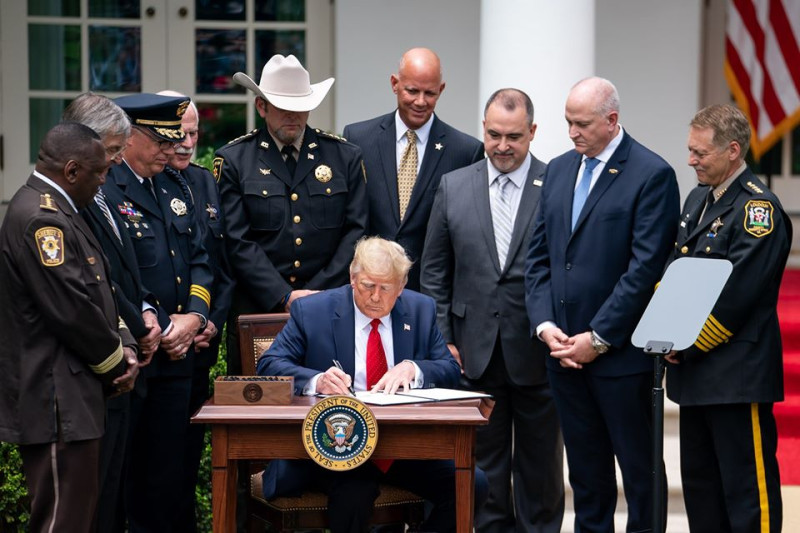 美國總統川普（中坐者）在白宮簽署1項針對警隊的行政命令，反對派完全沒有出席。   圖：翻攝自美國白宮臉書