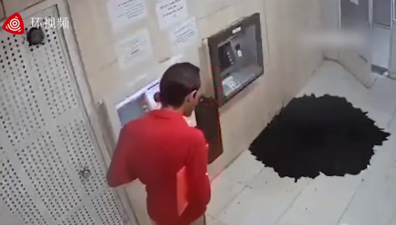 一名伊朗男子日前在當地一處ATM領錢時，提款機前的地面突然湧出大量黑色液體。   圖：翻攝自網路