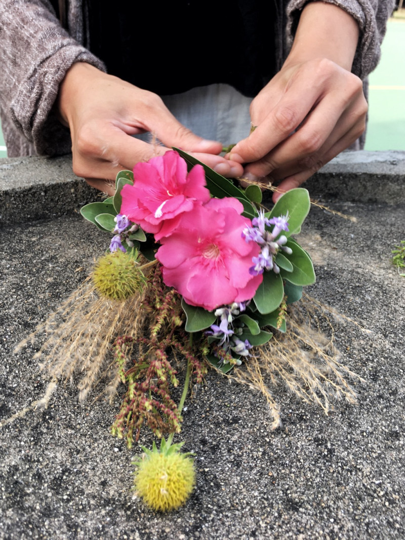大浦plus的工作人員強妮就地取材用東莒當地的蔓荊、團扇薺、五節芒、油菊、夾竹桃等植物作為花材為她編織獨特的畢業捧花。   圖：張良一/攝