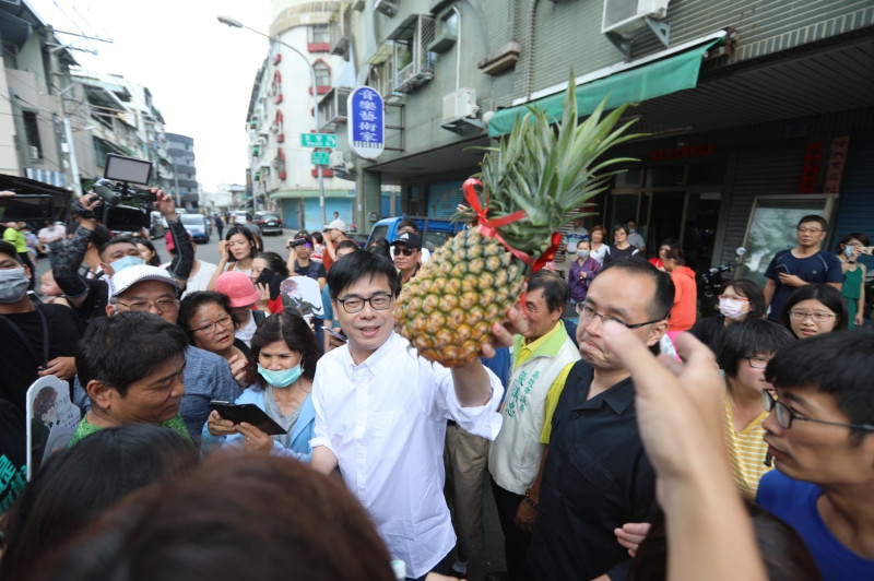 陳其邁(中)在市場拜票，民眾贈送象徵「旺來」的鳳梨。   圖：陳其邁競選團隊/提供