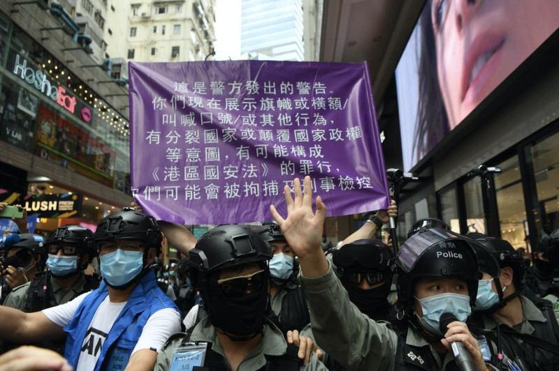 日前香港警方宣布破獲港獨組織「光城者」，以國安法24條恐怖活動罪，拘捕9人，而今天香港警務處國家安全處再拘捕至少5人。；圖為港警舉紫旗警告民眾。(示意圖)   圖：擷取自香港警察 Hong Kong Police