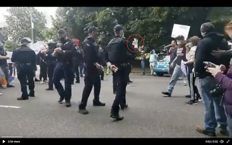 奧勒岡州警方向反BLM抗議者，比出具有白人至上主義意味的「OK」手勢。   圖：擷取至MsLisaHendricks Twitter影片