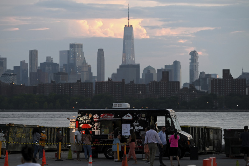 以世界貿易中心為背景，一輛食物卡車坐在紐約天際線開車入停車場附近，為觀眾提供食物和飲料 。因武漢肺炎，美國解除近三個月以上的封鎖，日前重新開放。   圖：達志影像 / 美聯社