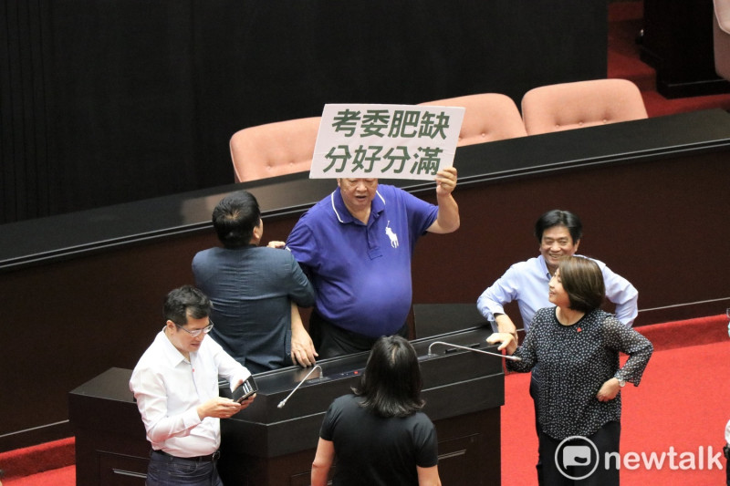 國民黨立委陳雪生(圖中舉牌男)遭范雲指控，今天上午在議場用肚子多次頂了她的背。   圖：謝孟華/攝(資料照片)