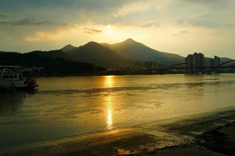 關渡自行車道沿著河邊騎行，欣賞落日風景。   圖：台北市工務局／提供