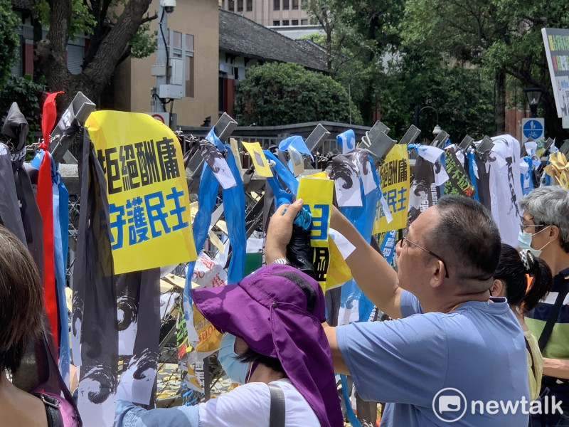 國民黨支持者在拒馬上掛上「拒絕酬庸,守護民主」的紙卡與緞帶。 圖:羅國嘉/攝