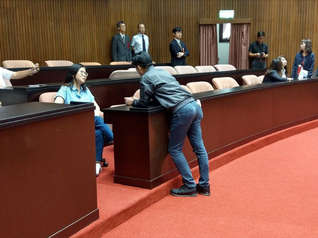 民進黨立委鄭運鵬今放上一張圖片，重點為議場桌子高度，但大家的焦點都在照片中的男子背影。   圖：翻攝自林俊憲臉書