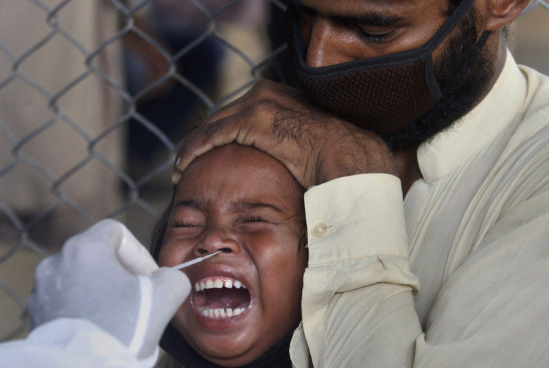 巴基斯坦一名小女孩正在做武漢肺炎檢測所做出的反應。   圖片來源：達志影像/美聯社