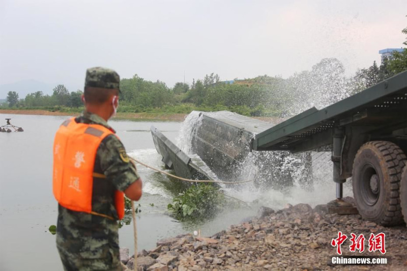 中國洪災，武警出動重機械，防堵堤防潰堤。   圖 : 翻攝自中新網