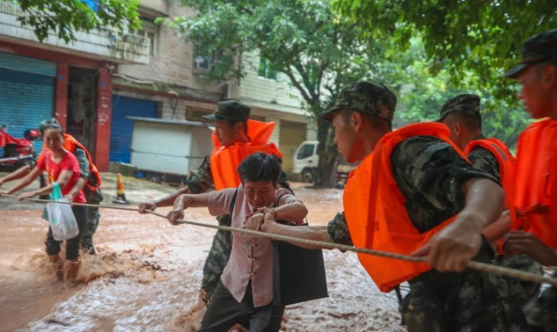 由於重慶市區大水未退，民眾在救援團隊幫助下撤離災區。   圖：翻攝自中新網