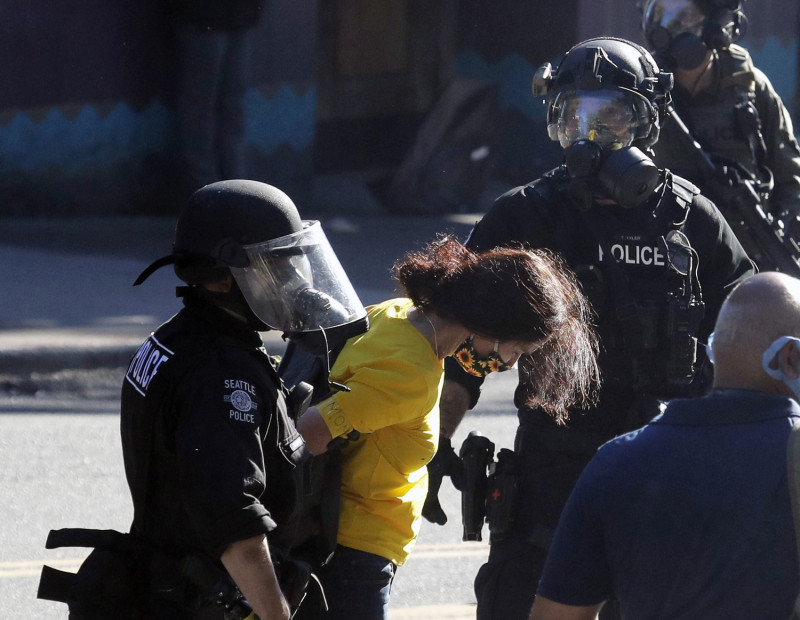 西雅圖民眾今天再次走上街頭，以「黑人的命也是命（Black Lives Matter）」為題舉辦遊行，過程中出現激進手段，遭到警方驅離、壓制。一名身穿黃衣的婦人被員警逮捕。   圖：達志影像/美聯社