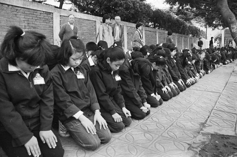 此圖是當年老蔣過世時，舉國哀悼的歷史畫面，小學生們跪在校外圍牆邊下跪，等候靈車通過。   圖：翻攝唐墨臉書粉絲專頁