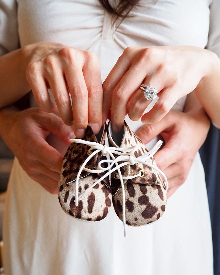 廖曉喬夫妻二人拿著乳牛斑紋造型的小鞋。   圖：翻攝廖曉喬臉書