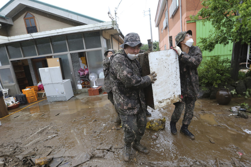 韓國秋原市遭受大雨洪水，陸軍士兵從受損房屋中運送殘骸。   圖：達志影像/美聯社