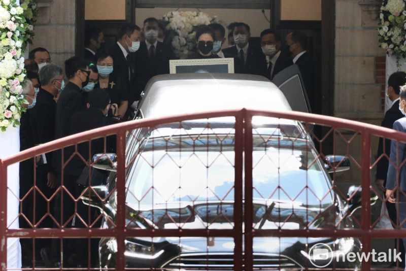全身著黑衣的孫女李坤儀手捧前總統李登輝的遺照，在先生趙贊凱的陪同上了靈車。   圖：攝影中心提供
