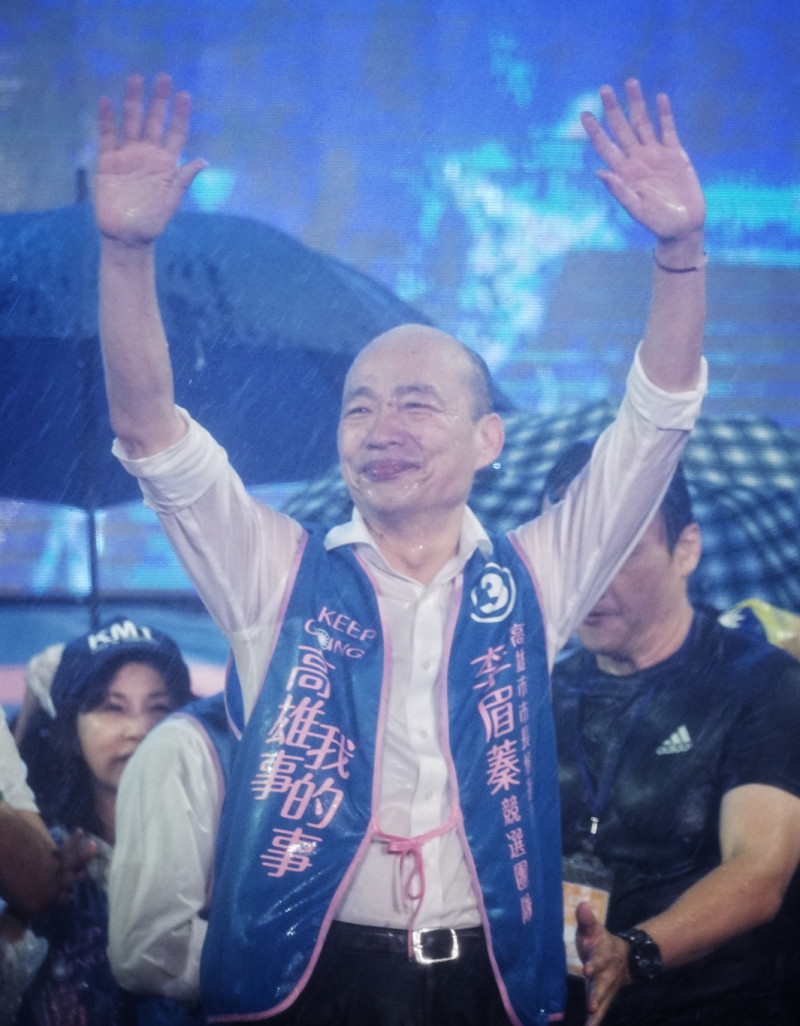韓國瑜在雷電交加的暴雨中，高舉雙手向支持者致意。   圖：張良一/攝