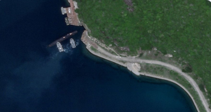 衛星拍到在兩艘軍艦下的一艘中國潛艇，正要進入位在海南島的地下基地。   圖 : 翻攝自Drake Long推特