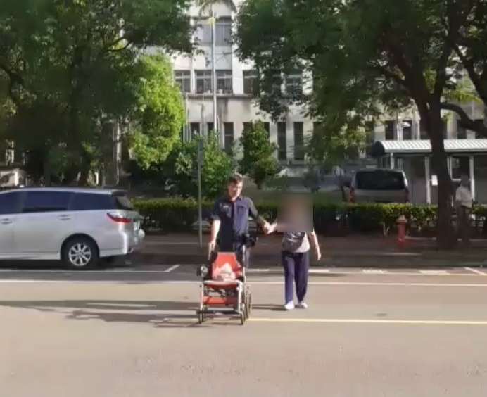 員警扶著人瑞老婦人過馬路。   警方/提供 