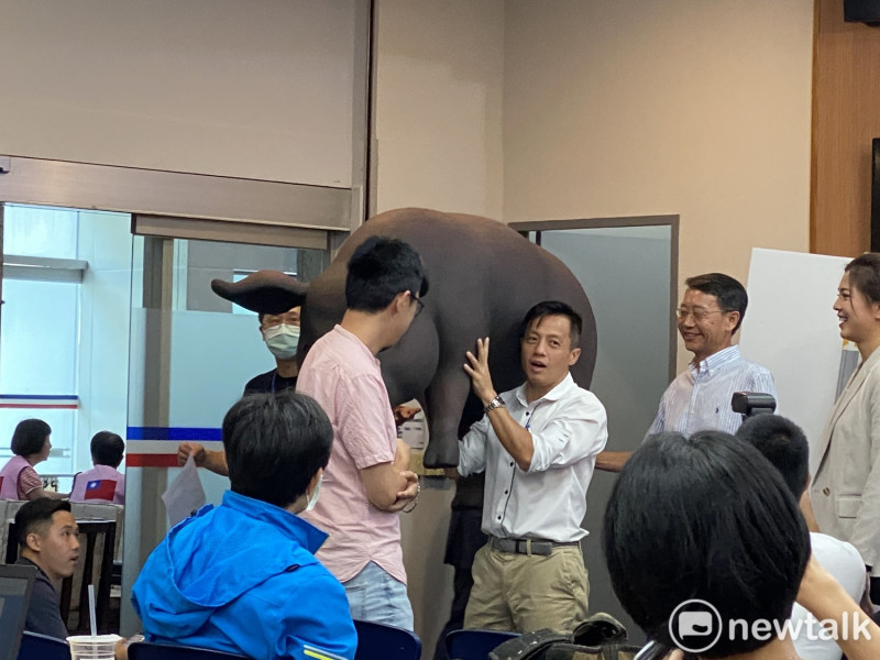 記者會結束後，國民黨市議員李明賢扛著黑毛豬模型離開現場。   圖：周煊惠 ／攝