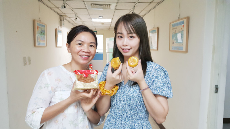 胡金玉嫦(左)說，椰子口味的月餅在越南也相當受歡迎，傳統月餅為圓形，寓意圓圓滿滿。右為胡金玉嫦的女兒陳金鈴展示臺式蛋黃酥。   圖：移民署/提供