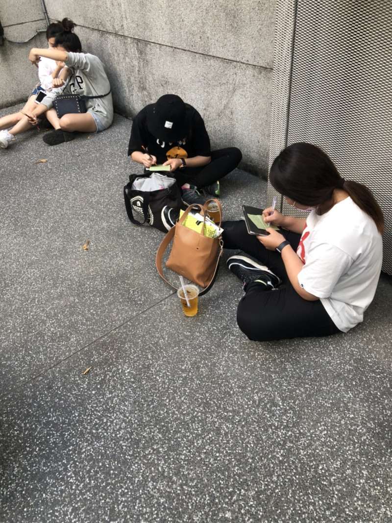 領到號碼牌的粉絲，坐在華山光點中廊，寫下他們想對小鬼黃鴻升說的話。   圖：楊瑾錚/攝