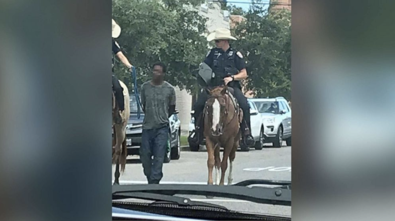 美國德州兩名白人騎警用繩索牽著一名黑人嫌犯「遊街」，引發爭議。   圖：翻攝自Erin Toberman臉書