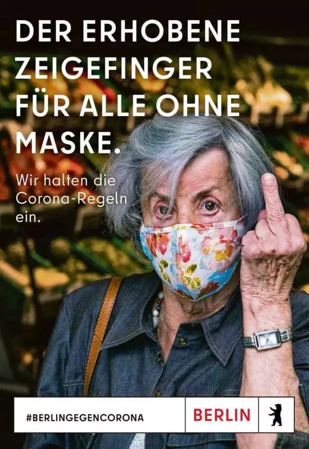 德國柏林出現一則宣導戴口罩的廣告，海報上的年長婦人戴著口罩比著中指。   圖：翻攝自Visit Berlin網站