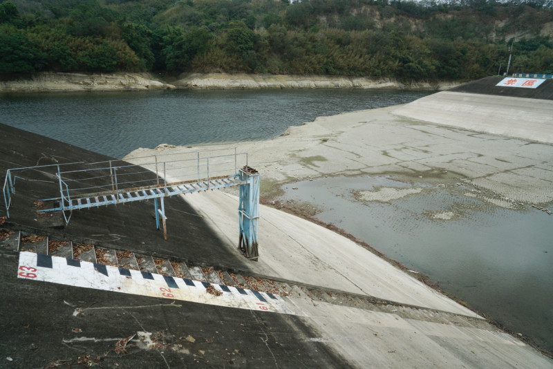 苗栗明德水庫蓄水量持續下降，23日的水庫水位降到51.45公尺，距離滿水位的61公尺，已下降近10公尺，蓄水量只有249.88萬立方公尺。大壩區的閘門下，一片乾旱，沙土龜裂。   圖：張良一/攝