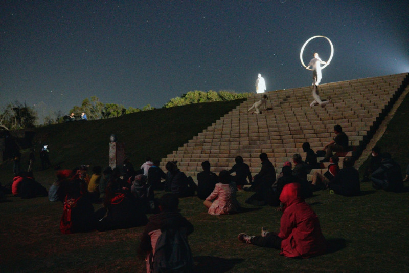 觀眾在大坵草坪席地而坐觀賞藝術家的聲音與肢體的演出。   圖：張良一/攝