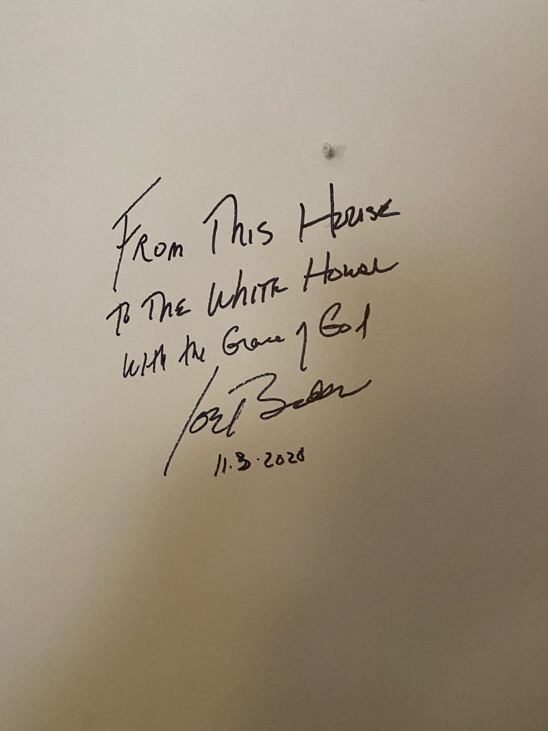 拜登在故居客廳一幅畫後的牆上寫道：「憑藉上帝的恩典，從這座房子到白宮。」   圖：翻攝推特