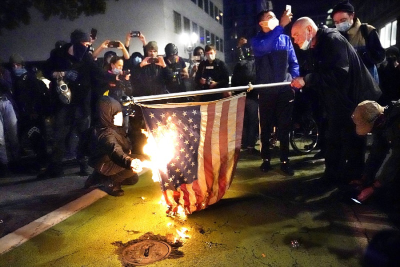 奧勒岡州波特蘭示威群眾高喊口號並焚燒美國國旗。   圖：達志影像/美聯社