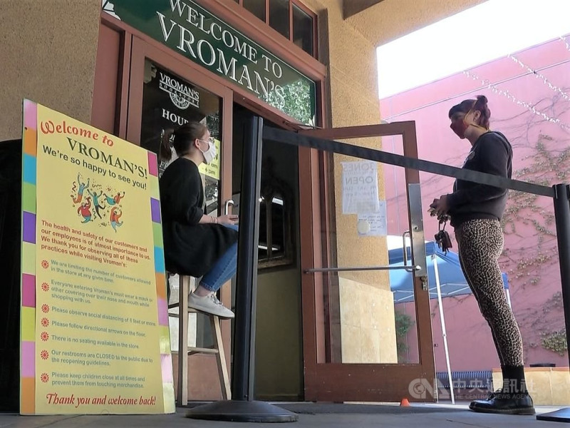 美國南加州最古老的獨立書店弗羅曼書店（Vroman's Bookstore）受疫情衝擊後重新開門，派人在店門口招呼客人，提醒防疫規則與書店動線。   圖：中央社／提供