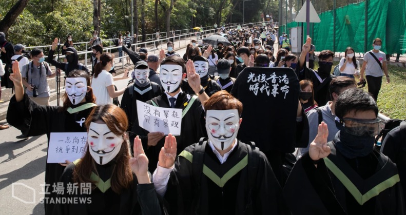 逾百名香港中文大學學生發起校內「畢業遊行」，高舉「光復香港、時代革命」、「香港獨立」等布條和旗幟，並聲援仍被扣押在中國的12名港人。   圖：翻攝立場新聞臉書