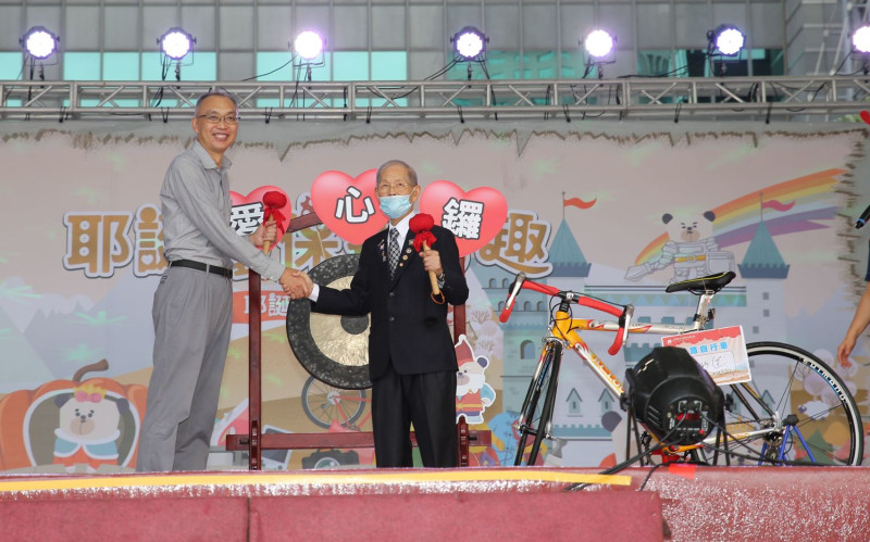 副市長謝政達（左）拍賣一輛公路自行車，由扶輪社黃火木以 1萬7000元得標，響應環保送愛心。   圖：新北市環保局提供 