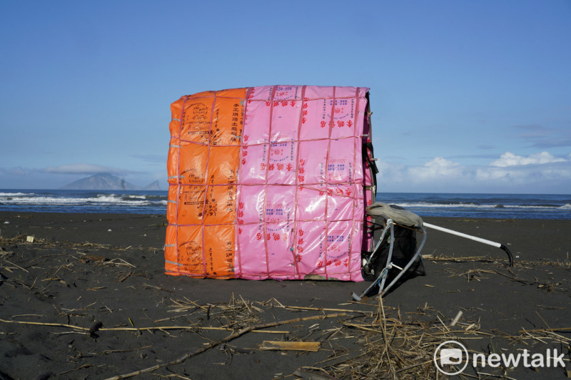 基隆著名李鵠餅店的塑膠提袋出現在宜蘭蘭陽溪出海口，被轉換成包覆小烏龜的『外殼』。   圖：張良一/攝