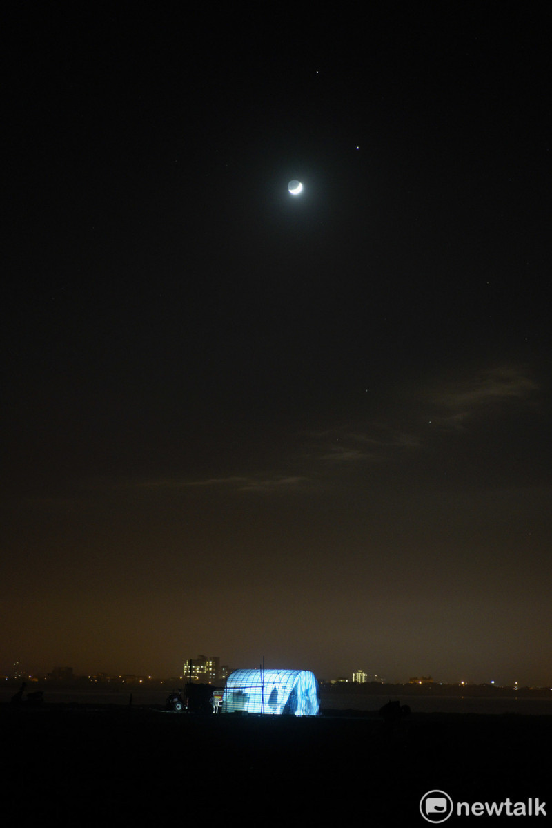 入夜後，海灘上的漁寮燈火與天上的月亮、土星和木星相互輝映。   圖：張良一/攝