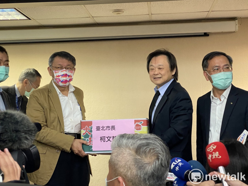 台北市長柯文哲（左）贈送一箱橘子給議會警政衛生委員會，由民進黨議員王世堅（右2）接下。兩人難得和樂融融地同框。   圖：周煊惠／攝
