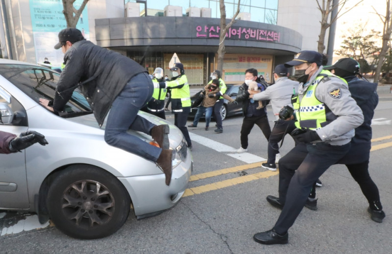 南韓性侵犯趙斗淳出獄，氣憤的民眾跳上載著趙斗淳的車輛抗議。   圖 : 翻攝自環球網