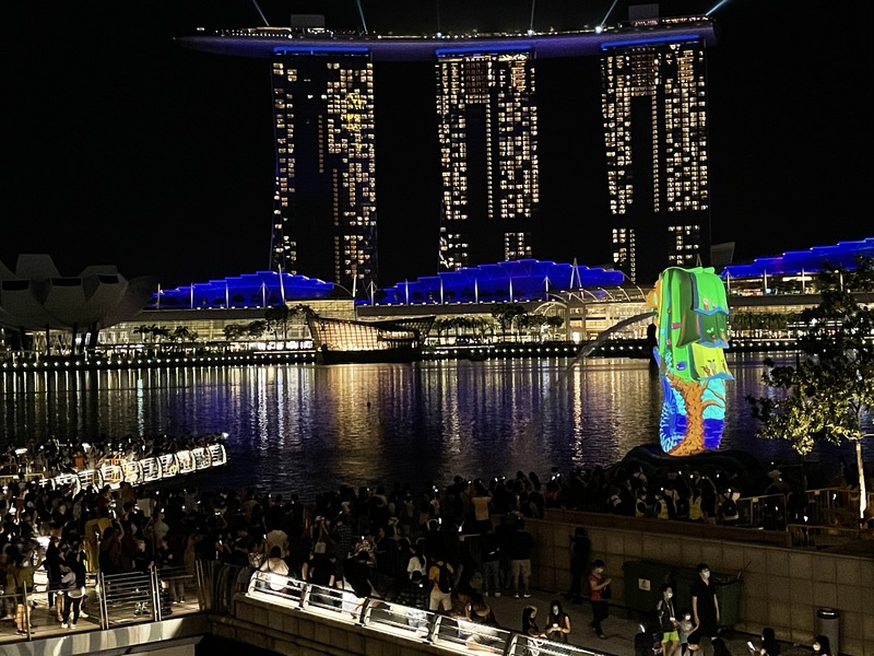 受疫情影響，新加坡濱海灣跨年倒數活動少了煙火秀，改由回顧疫情期間暖心故事的投影秀迎接2021年，魚尾獅瞬間變得五彩繽紛。   圖：中央社提供