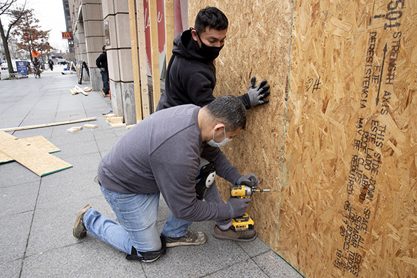華盛頓特區當地許多商家使用木板加強商店、大樓門窗，以應對川普支持者進行抗議活動時，可能帶來的破壞。   圖：翻攝自環球網