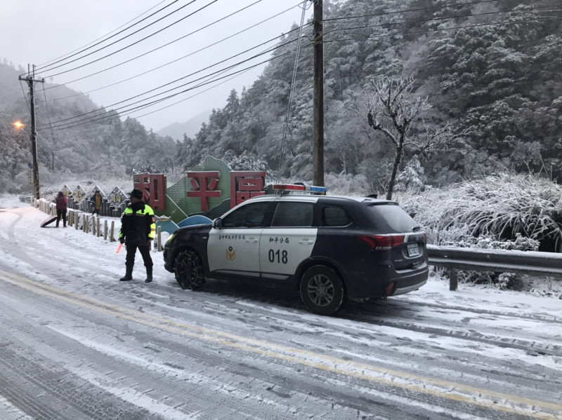 台中市與宜蘭縣交界處的「思源埡口」今（8）日清晨飄起白雪，和平警方在雪中執勤。   和平警分局/提供