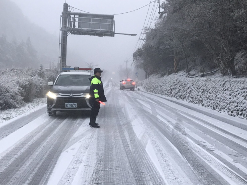 台中市與宜蘭縣交界處的「思源埡口」今（8）日清晨飄起白雪，和平警方在雪中執勤。   和平警分局/提供