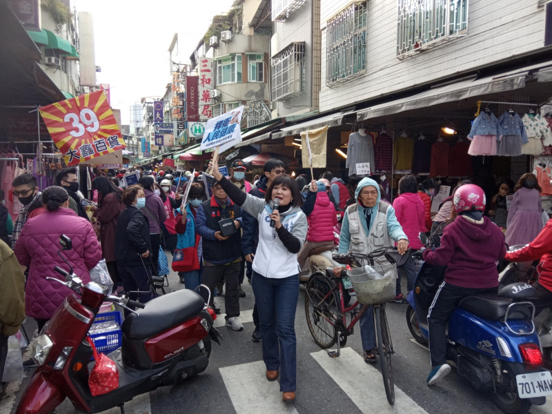 陳若翠(中)率志工在三和市場舉牌宣導反萊豬公投二階連署。   圖：孫家銘/攝