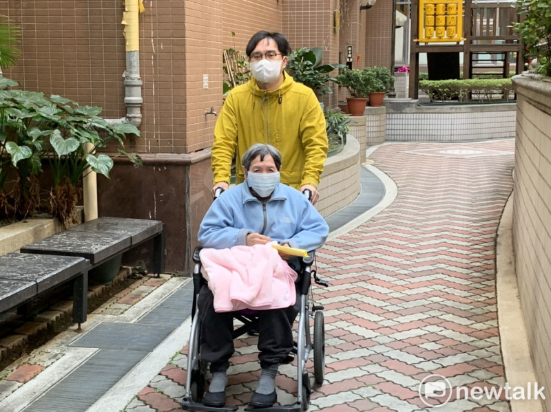 唐平榮推著坐輪椅的阿嬤一同前往投開票所投票。   圖：林昀真／攝