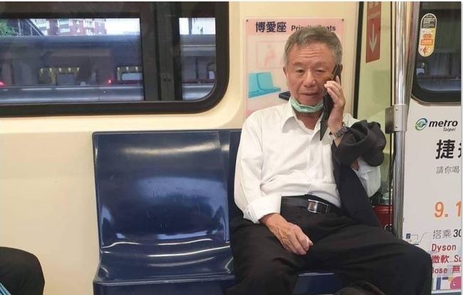 楊志良遭臉書粉專爆出他搭乘捷運時，把口罩拉下至下巴講電話。   圖：翻攝自臉書水鏡政經學院