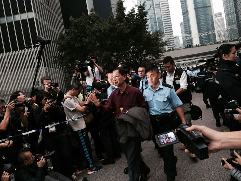 香港民主黨創始主席李柱銘（中戴眼鏡者）2014年也曾參與雨傘運動被捕，始終不改其志，與爭取自由民主的香港年輕人站在一起。   圖：翻攝自維基網站/湯惠芸提供