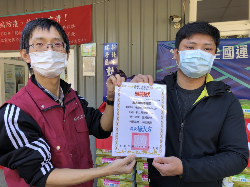 瑞芳動物之家獸醫王嚴緒（左）致贈感謝狀給「大漁丸愛心專班」成員。   圖：新北市動保處提供